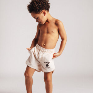 Jongen in korte broek, lachend zwembroek baje