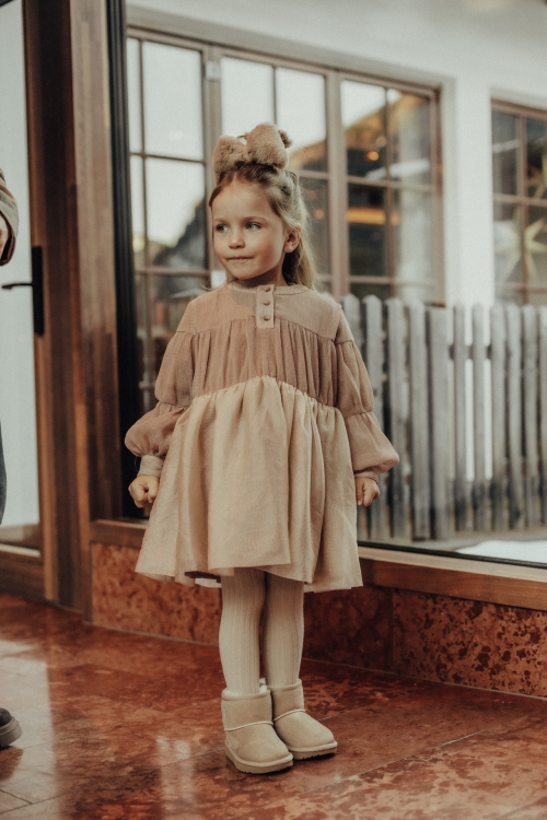 Meisje in schattige jurk en schoenen