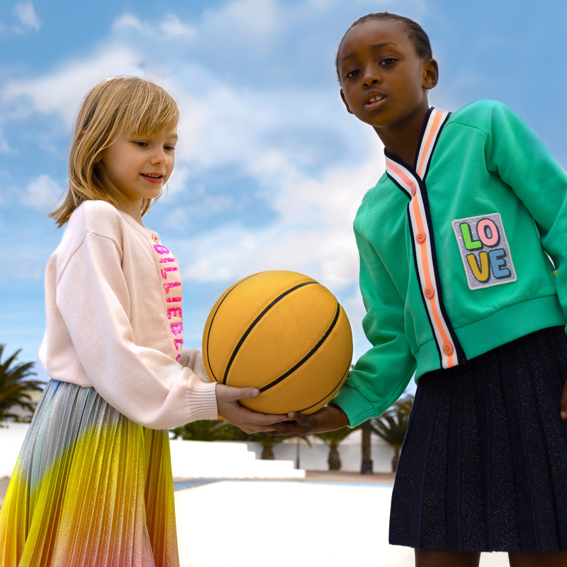 Modefoto met Billieblush plooirok in metallic regenboogkleuren, gedragen door meisje