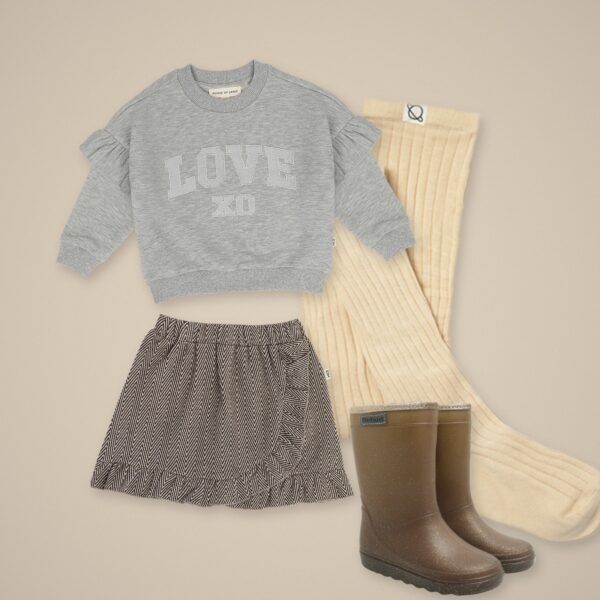 Grijze sweater, rokje met ruches, ivoorwitte maillot en glitterlaarzen