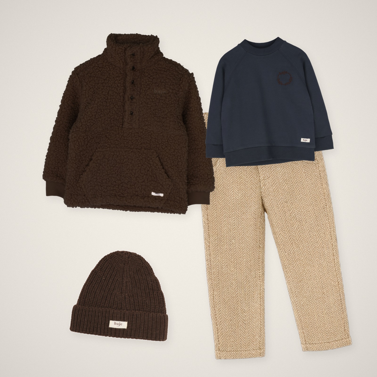 Outfit jongens winter: Baje Studio blauwe oversized trui, broek Carth taupe, jas Yagger en muts Snowie
